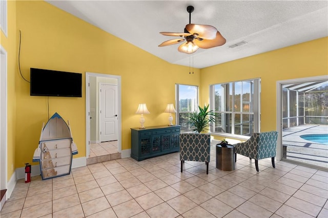 interior space featuring vaulted ceiling, a textured ceiling, and ceiling fan