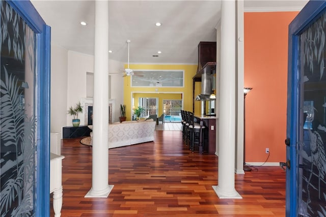 entrance foyer featuring wood-type flooring, ornamental molding, ceiling fan, and ornate columns