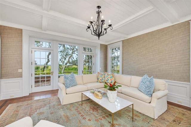 144 Point Ln, Saint Simons Island, GA 31522 - living room featuring healthy amount of natural light, a chandelier, wood finished floors, beamed ceiling, and a wainscoted wall