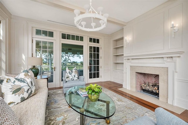 144 Point Ln, Saint Simons Island, GA 31522 - living area with a chandelier, built in shelves, a premium fireplace, wood finished floors, and beam ceiling