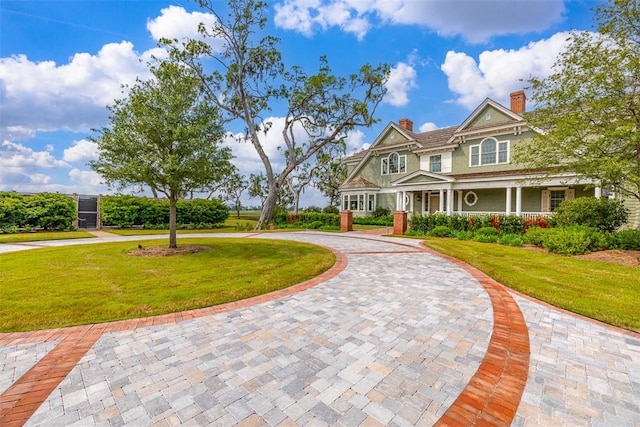 144 Point Ln, Saint Simons Island, GA 31522 - view of front of house featuring curved driveway, a front yard, a chimney, and a porch
