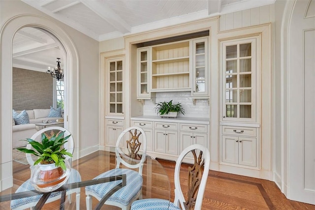 144 Point Ln, Saint Simons Island, GA 31522 - dining space with beamed ceiling, wood finished floors, a chandelier, baseboards, and ornamental molding