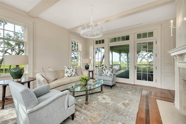 144 Point Ln, Saint Simons Island, GA 31522 - living area featuring a chandelier, beamed ceiling, wood finished floors, a decorative wall, and a premium fireplace