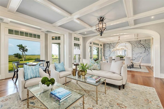 144 Point Ln, Saint Simons Island, GA 31522 - living room featuring a chandelier, arched walkways, coffered ceiling, wood finished floors, and plenty of natural light