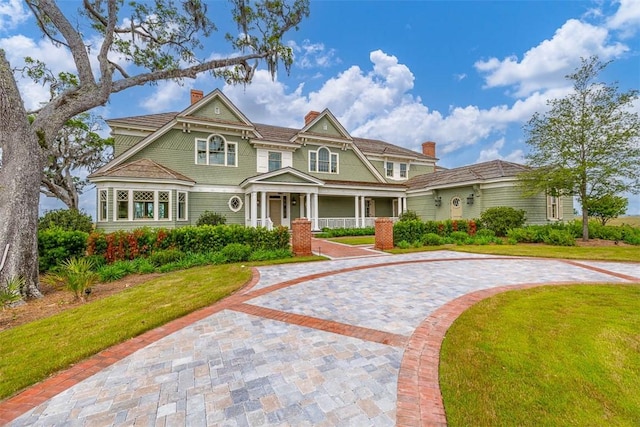 144 Point Ln, Saint Simons Island, GA 31522 - shingle-style home with a chimney, a front lawn, curved driveway, and a porch