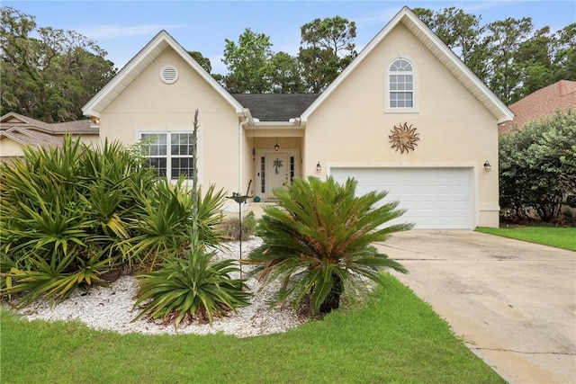 11 Niblick Ct, Saint Simons Island, GA 31522 - view of front of house with stucco siding, driveway, and an attached garage