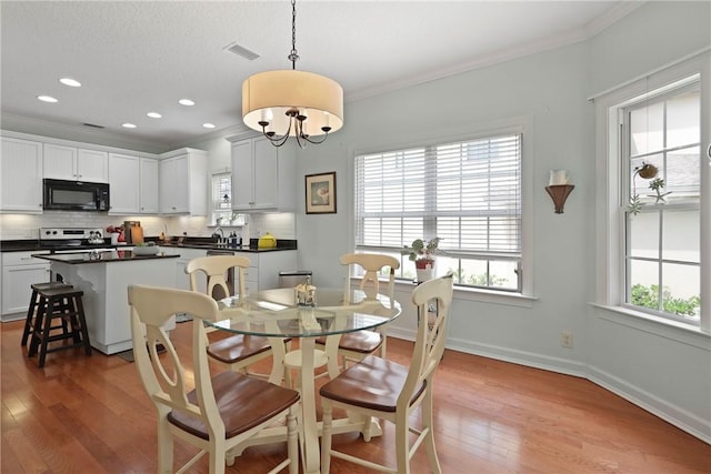 11 Niblick Ct, Saint Simons Island, GA 31522 - dining area with light wood finished floors, ornamental molding, baseboards, recessed lighting, and a chandelier
