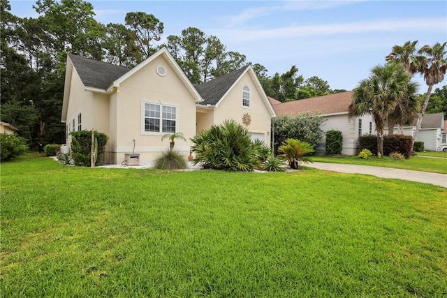 11 Niblick Ct, Saint Simons Island, GA 31522 - view of front of house featuring a front yard, a garage, stucco siding, and roof with shingles