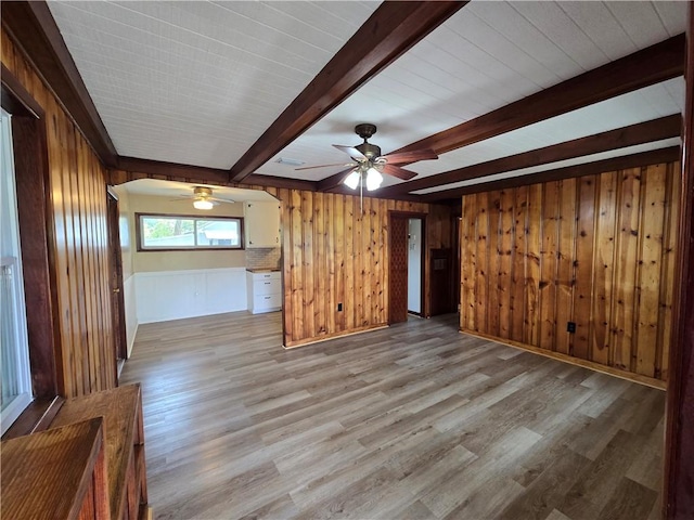 554 Blythe Island Dr, Brunswick, GA 31523 - unfurnished living room with beamed ceiling, wooden walls, ceiling fan, and light wood-style floors