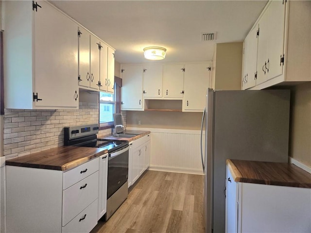 554 Blythe Island Dr, Brunswick, GA 31523 - kitchen featuring stainless steel electric range oven, freestanding refrigerator, light wood-type flooring, backsplash, and wainscoting