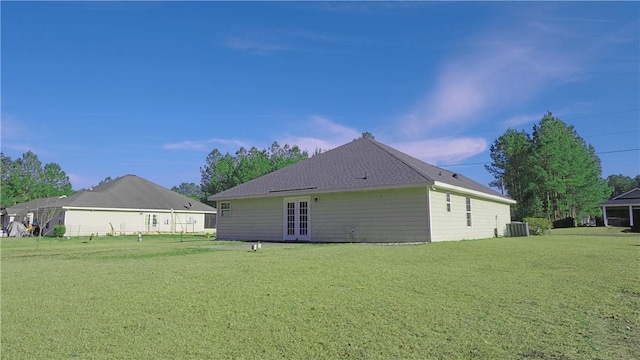 rear view of property featuring a yard, central AC unit, and french doors