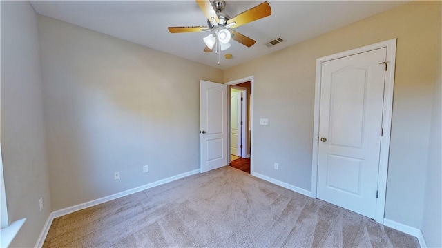 unfurnished bedroom with ceiling fan and light colored carpet