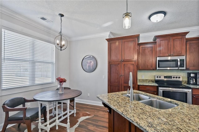 kitchen with dark wood-type flooring, sink, light stone counters, hanging light fixtures, and appliances with stainless steel finishes