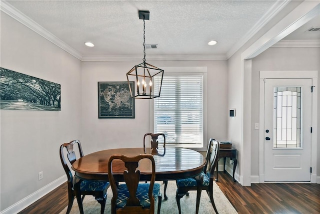 dining room with dark wood-type flooring, ornamental molding, and a textured ceiling