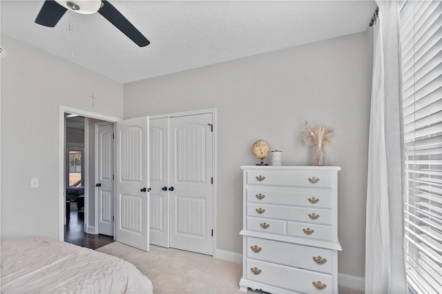 carpeted bedroom with ceiling fan and a closet