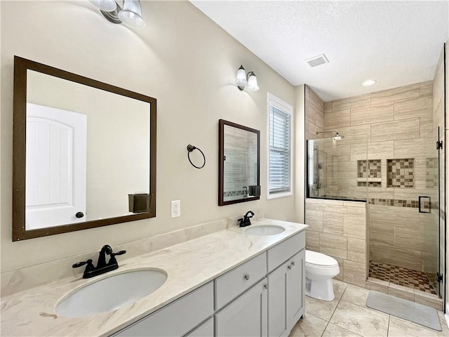 bathroom featuring walk in shower, toilet, a textured ceiling, vanity, and tile patterned flooring