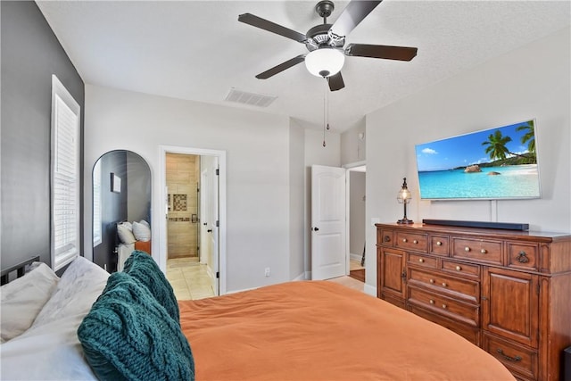 tiled bedroom with ensuite bath and ceiling fan