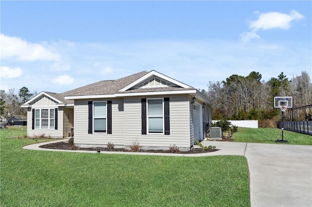 view of front of house with a garage, central AC, and a front lawn