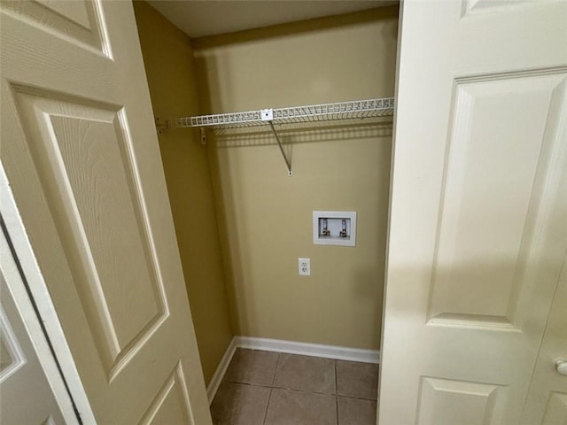 laundry area with hookup for a washing machine, dark tile patterned flooring, and baseboards