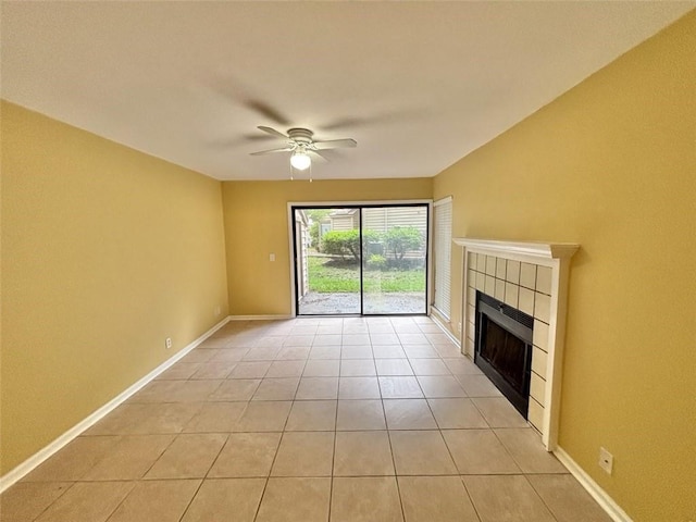 unfurnished living room featuring light tile patterned floors, a ceiling fan, a tiled fireplace, and baseboards