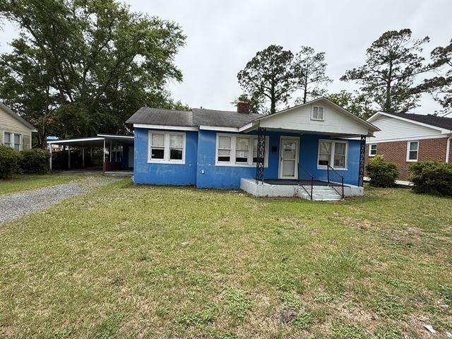 511 Riverside Dr, Waycross, GA 31501 - bungalow-style house featuring covered porch, a carport, a front lawn, and a chimney