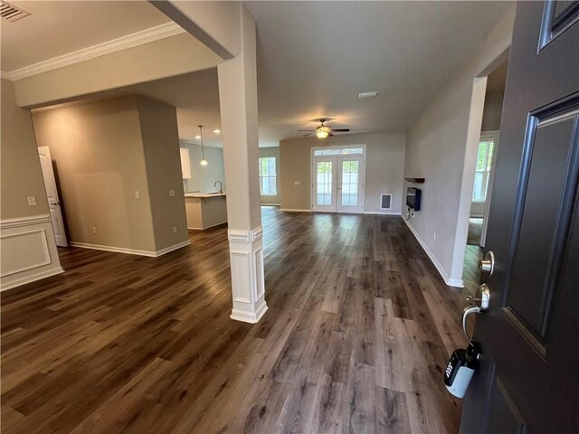 unfurnished dining area with dark hardwood / wood-style floors, crown molding, and a notable chandelier