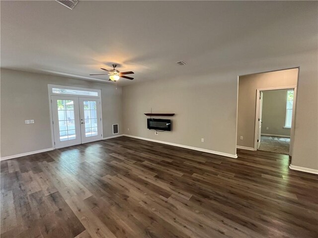 empty room with dark colored carpet, crown molding, a raised ceiling, and ceiling fan