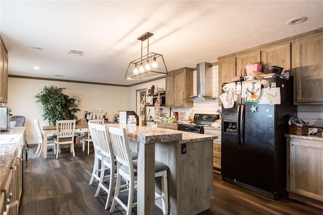 kitchen featuring dark wood-style floors, a kitchen island, wall chimney range hood, and black appliances