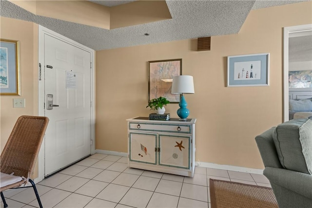 tiled entrance foyer with a textured ceiling