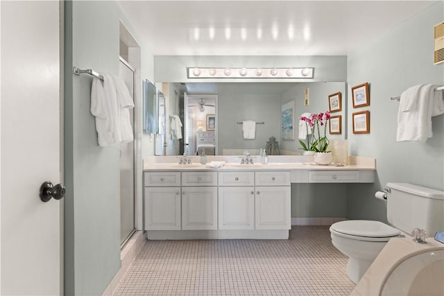 bathroom with tile patterned floors, walk in shower, vanity, ceiling fan, and toilet