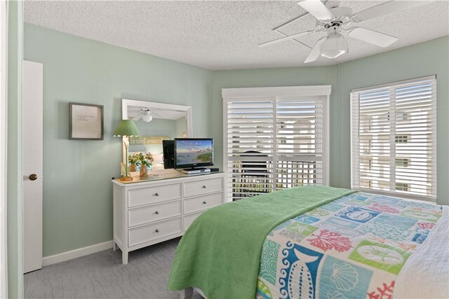 bedroom featuring light carpet, a textured ceiling, and ceiling fan