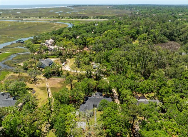 drone / aerial view of a heavily wooded area and a large body of water