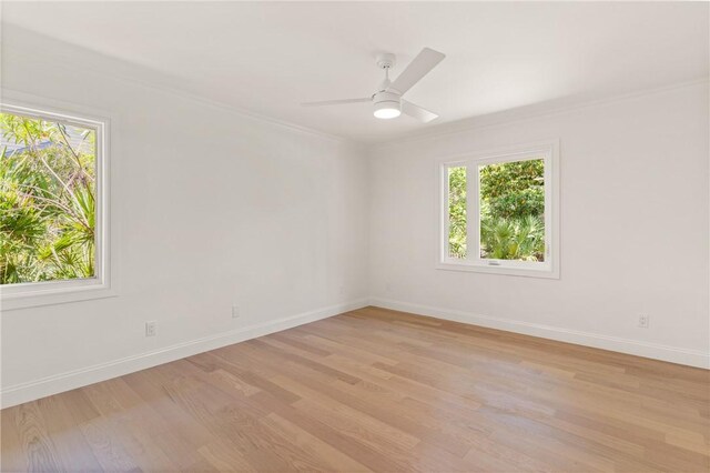 empty room with light wood-style floors, baseboards, crown molding, and ceiling fan