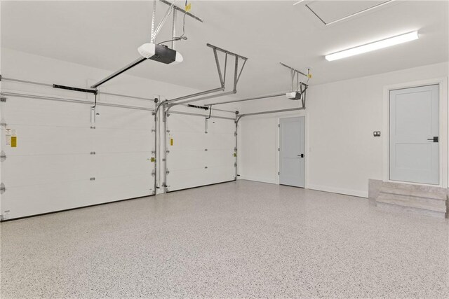 garage featuring a garage door opener and baseboards