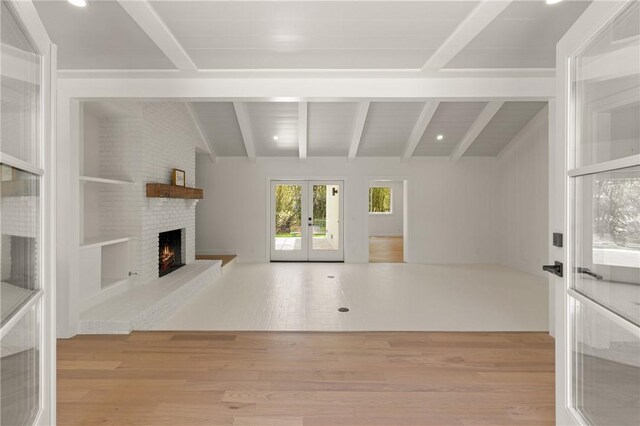 unfurnished living room featuring french doors, a fireplace, wood finished floors, and recessed lighting