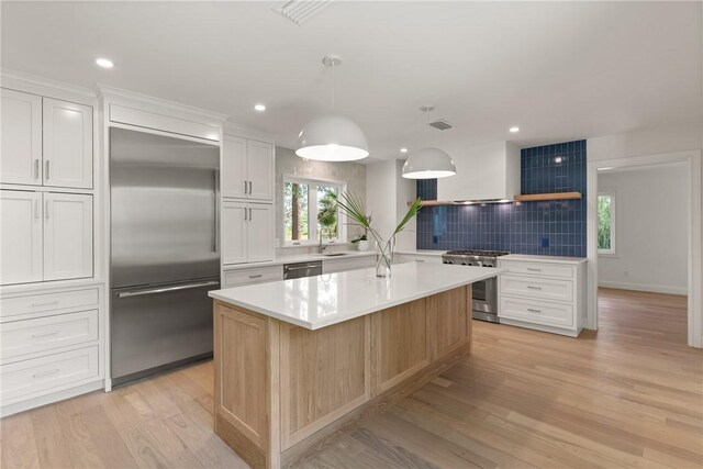 kitchen featuring stainless steel appliances, tasteful backsplash, light countertops, healthy amount of natural light, and recessed lighting