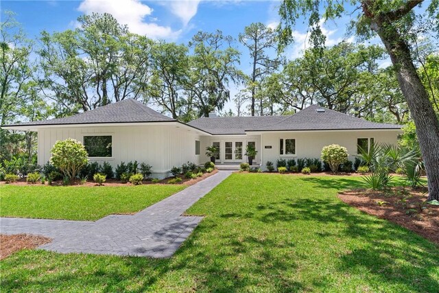 view of front of home with french doors, a front lawn, and a chimney