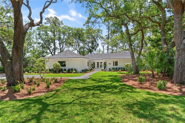 back of house featuring a lawn and french doors