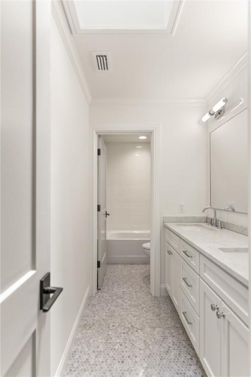 bathroom with toilet, ornamental molding, double vanity, a bathtub, and a shower