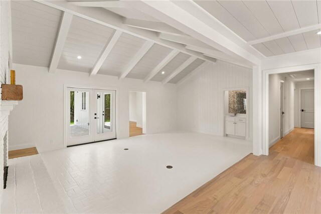 unfurnished living room featuring light wood finished floors, french doors, wood ceiling, and baseboards
