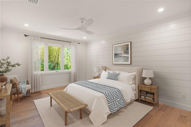 bedroom with baseboards, light wood-style floors, recessed lighting, a ceiling fan, and wooden walls