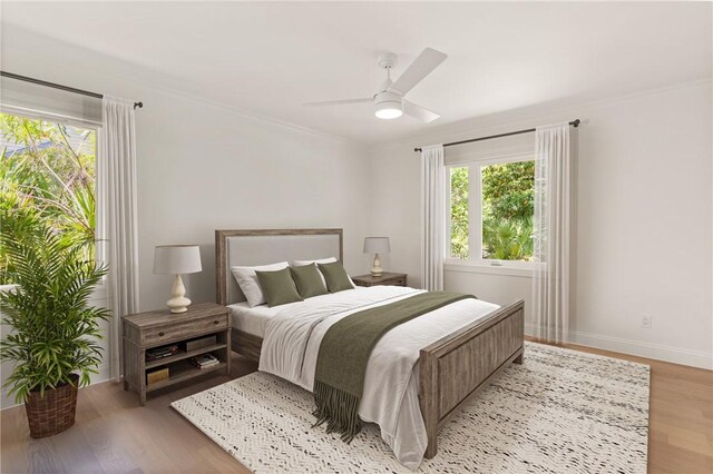 bedroom featuring light wood-style floors, baseboards, ceiling fan, and ornamental molding