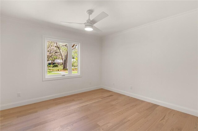 empty room with light wood finished floors, crown molding, baseboards, and ceiling fan
