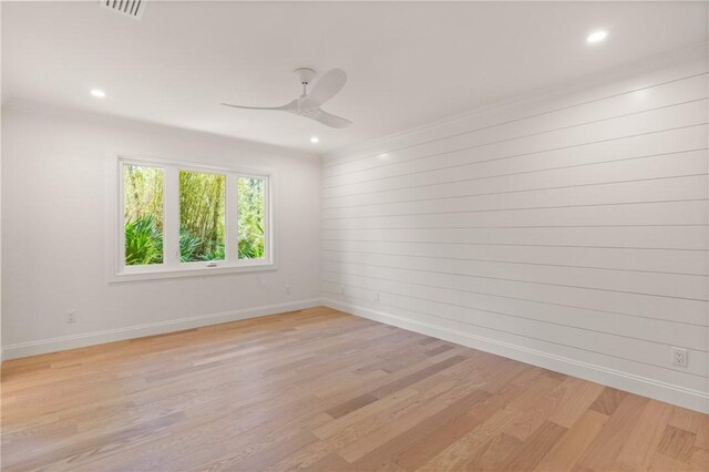 empty room with baseboards, a ceiling fan, light wood-style floors, recessed lighting, and crown molding