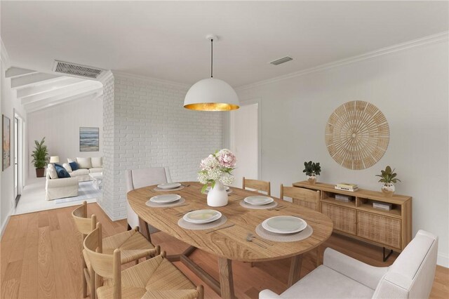 dining room with wood finished floors, crown molding, and vaulted ceiling
