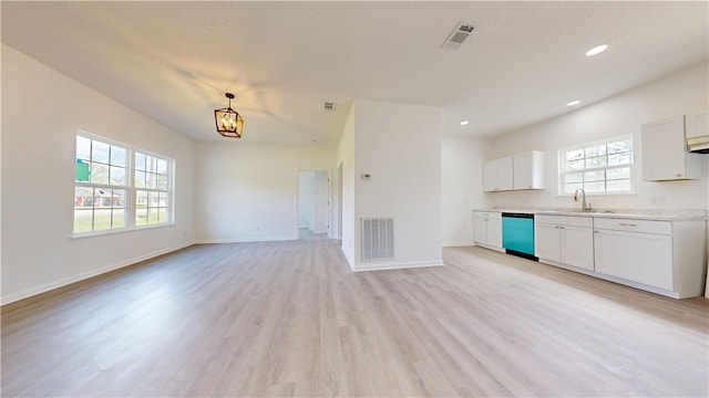 kitchen with a sink, visible vents, light wood-type flooring, and dishwasher