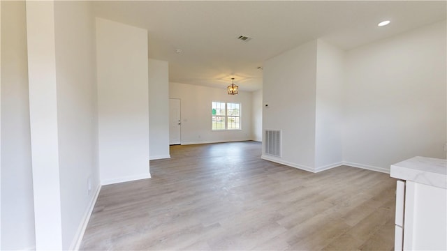 spare room with baseboards, visible vents, and light wood-style flooring