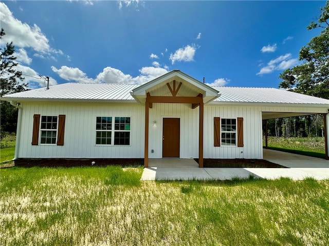 view of front of home featuring a front lawn, metal roof, and a carport