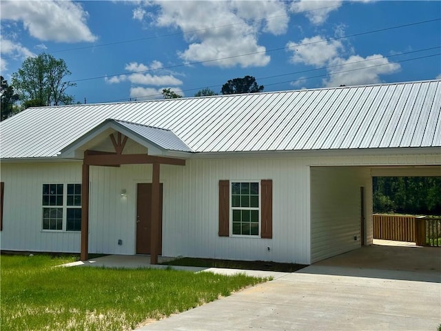 single story home featuring a front yard, a carport, and metal roof