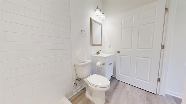 bathroom featuring toilet, wood finished floors, and vanity